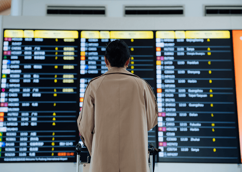 Woman from behind looking at digital signage in airport