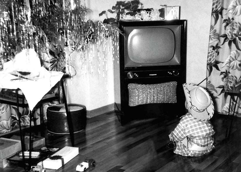 Young boy looking at TV set on Christmas in 1950s